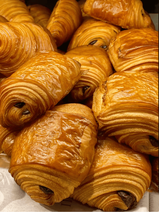 Conjunto de croasanes rellenos de chocolate apilados uno encima del otro